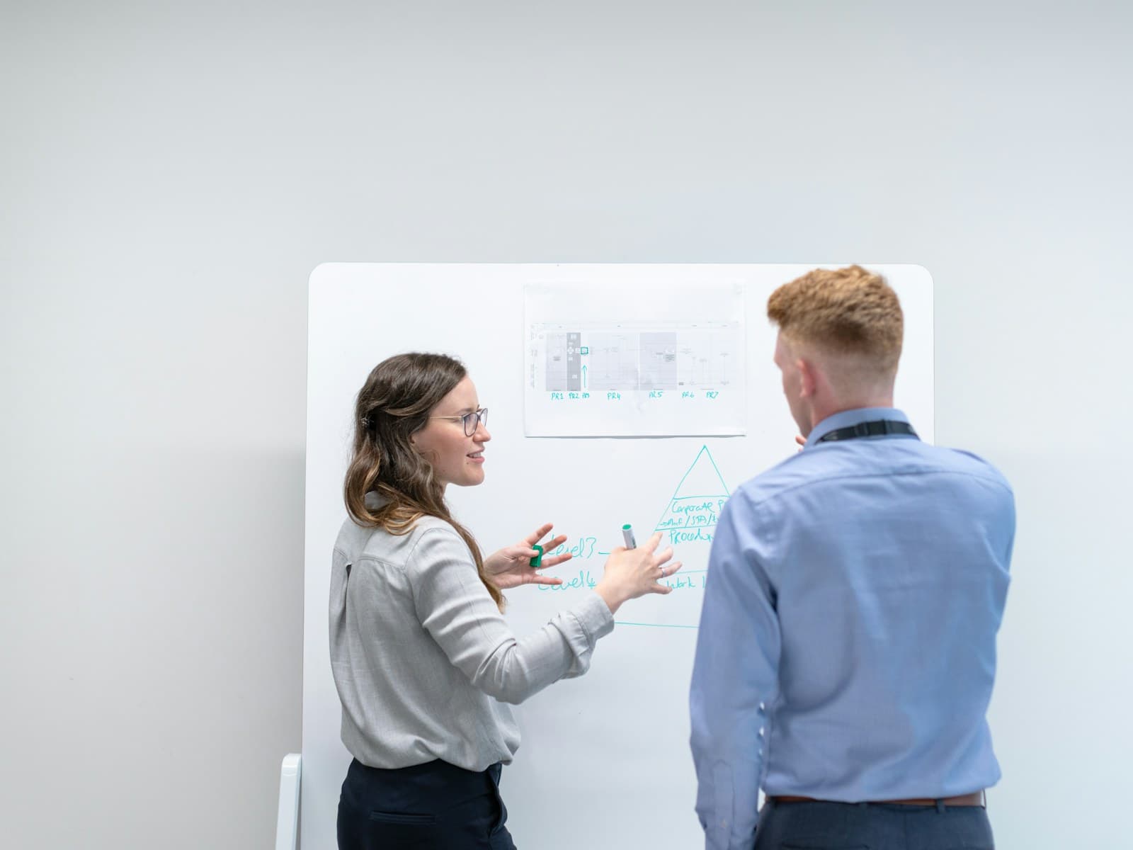 Deux ingénieurs discutant d’une architecture devant un tableau blanc